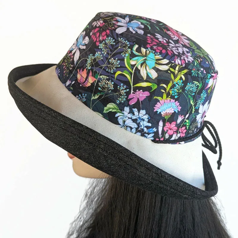 Sunblocker UV summer sun hat with wide brim, featuring pretty flowers on black, adjustable fit